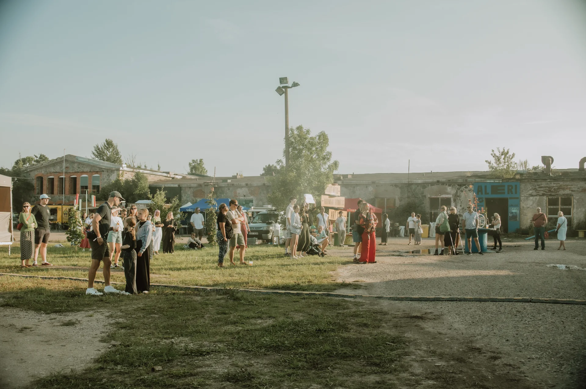 Külastajad suvisel kultuuriüritusel Viscosa Kultuuritehase hoovis Hiiumaal, ajaloolise kalatehase toimuv kogukondlik kultuurielu kohalikele ja külalistele. Foto: Kirke Kuiv.