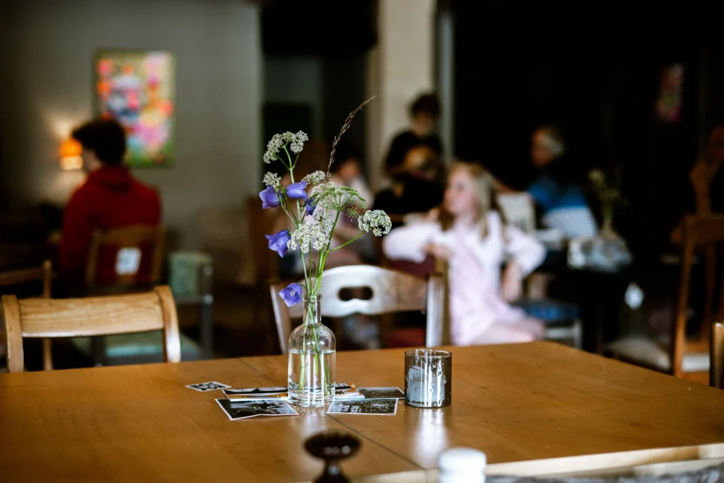 RIBE Catering Viscosa Kultuuritehase restoranis, külalised laua taga ootamas, laual suvised lilled.
